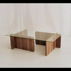 two wooden tables with glass top sitting on a white surface