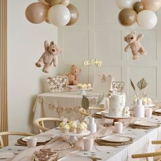 a table set for a baby's first birthday party with balloons and teddy bears