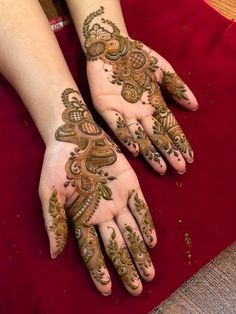 two hands with henna tattoos on them