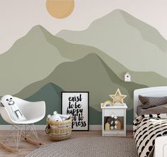 a bedroom with mountains painted on the wall and a rocking chair in front of it