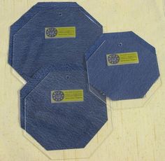 three blue hexagonal tags with yellow labels on them