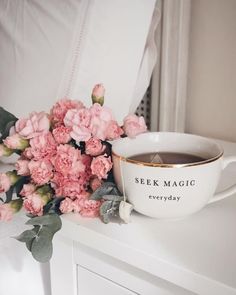 a cup of tea and some pink flowers