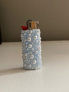 a lighter with pearls on it sitting on a table
