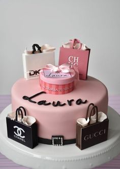 a pink cake with shopping bags on top