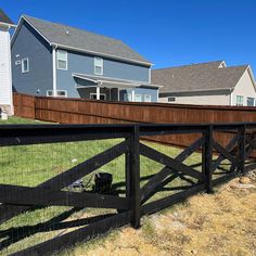 a fenced in yard with some houses behind it