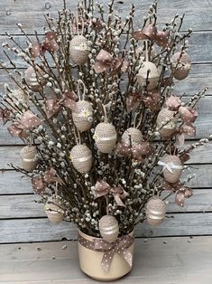 a vase filled with lots of ornaments on top of a wooden table next to a wall