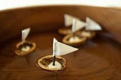 small sail boats are sitting in a wooden bowl