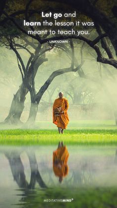 a person in an orange robe is walking through the grass with trees and water behind them