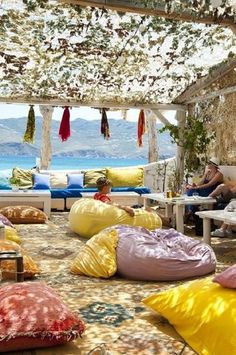 several bean bags are on the ground in front of some people sitting at tables and chairs