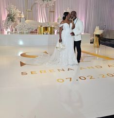 a bride and groom standing on the dance floor at their wedding reception in front of an elegant backdrop