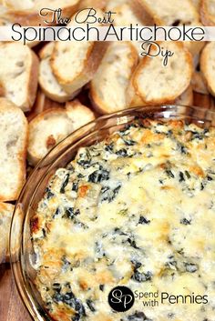 spinach artichoke dip in a glass dish on a wooden table with bread