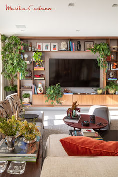 a living room filled with furniture and a flat screen tv mounted on a wall next to a window