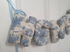 a blue and white stuffed animal hanging on the wall next to a door with ribbon