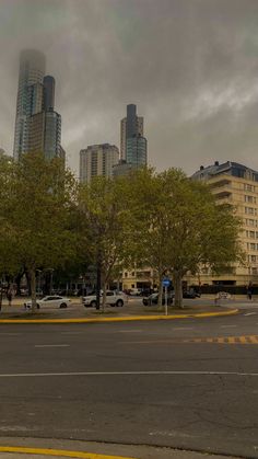 an empty street with tall buildings in the background