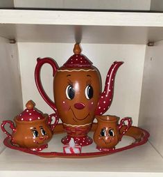 there is a tea set on the shelf