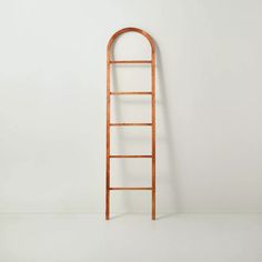 an old wooden ladder leaning against a white wall