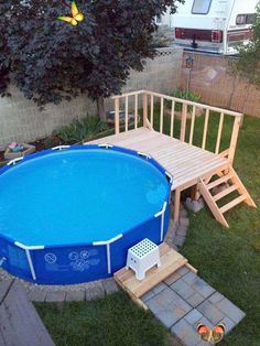 an above ground swimming pool with steps leading up to it and a deck in the back yard