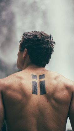 a man with a cross tattoo on his back