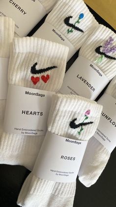 seven pairs of socks with embroidered hearts on them, all in white and black colors