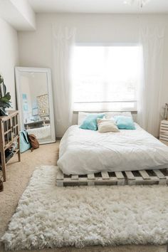 a bedroom with a bed made out of pallets and white rugs on the floor