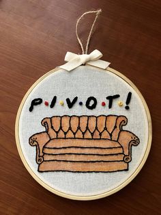 a hand embroidered ornament with the word pivot on it and a couch