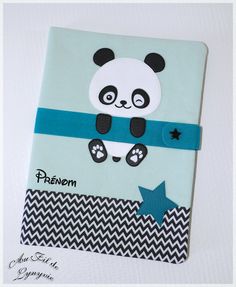 a small notebook with a panda bear on it's cover and blue ribbon around the edge