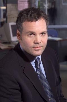 a man wearing a suit and tie sitting in an office