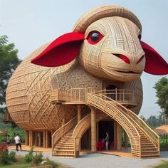 a large wooden sheep sculpture with stairs leading up to it's entrance and people standing in the doorway