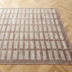 a brown and white area rug on top of a wooden floor