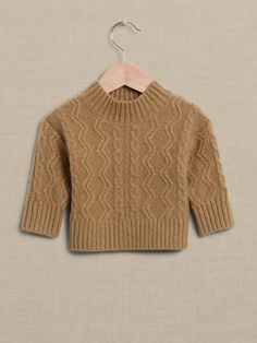 a brown sweater hanging on a wooden hanger