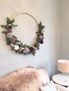 a wreath is hanging on the wall above a couch with pillows and a fur rug