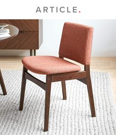 an orange chair sitting on top of a white rug