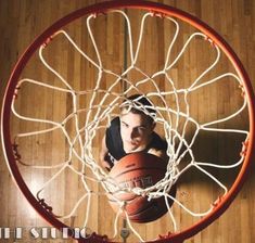 a young man is playing basketball in the hoop while looking down at him from above