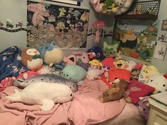 a bed with many stuffed animals on top of it in a room filled with toys