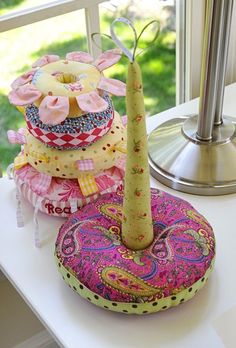 a stack of donuts sitting on top of a table next to a vase filled with flowers