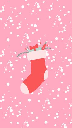 a christmas stocking with presents hanging from it's side on a pink background