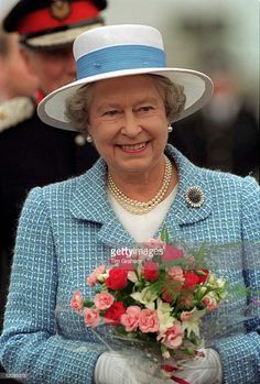 the queen smiles as she holds flowers at an event in london on may 29, 2013