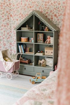 a child's room with a book shelf and toy baby carriage