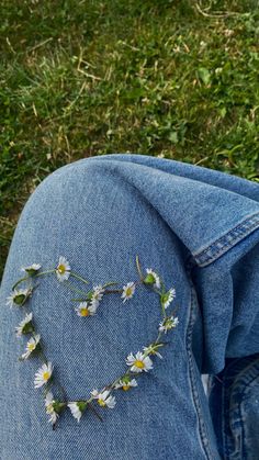 a heart made out of daisies on the back of someone's jeans