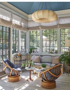 a living room filled with lots of furniture and windows covered in shades on the ceiling