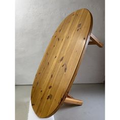 a wooden surfboard sitting on top of a white pedestal