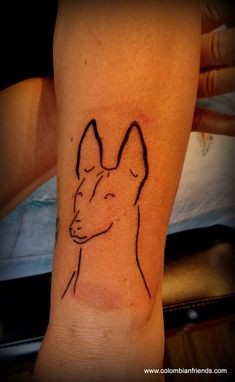 a tattoo on the leg of a person with a dog's head drawn on it