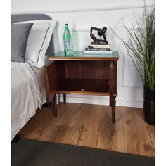 a bed room with a neatly made bed and a night stand next to a nightstand