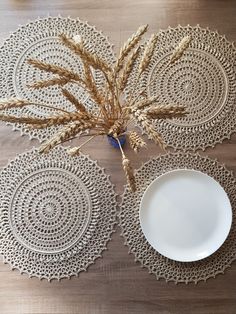 a white plate sitting on top of a wooden table next to a vase filled with flowers