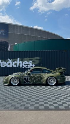 a green sports car parked in front of a building with the words redches on it