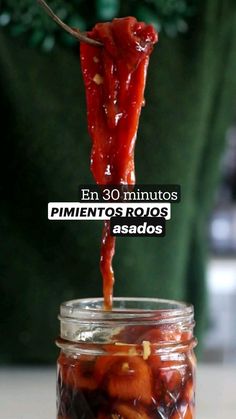 a person holding a spoon full of pickled peppers with the words, en 30 minutos pimentoos rojos asados