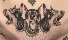 a man's chest with three dogs on it and one dog has its mouth open