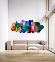 a living room with a couch, table and colorful artwork on the wall above it