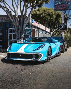 a blue and white sports car parked on the street