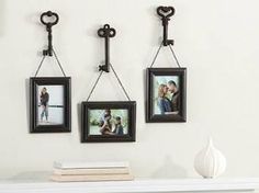 three pictures hanging on the wall with two key hooks